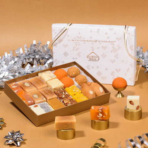 Almond House Assorted Sweets box featuring 12 varieties of traditional Indian sweets in elegant gift packaging, displayed with festive decorations.