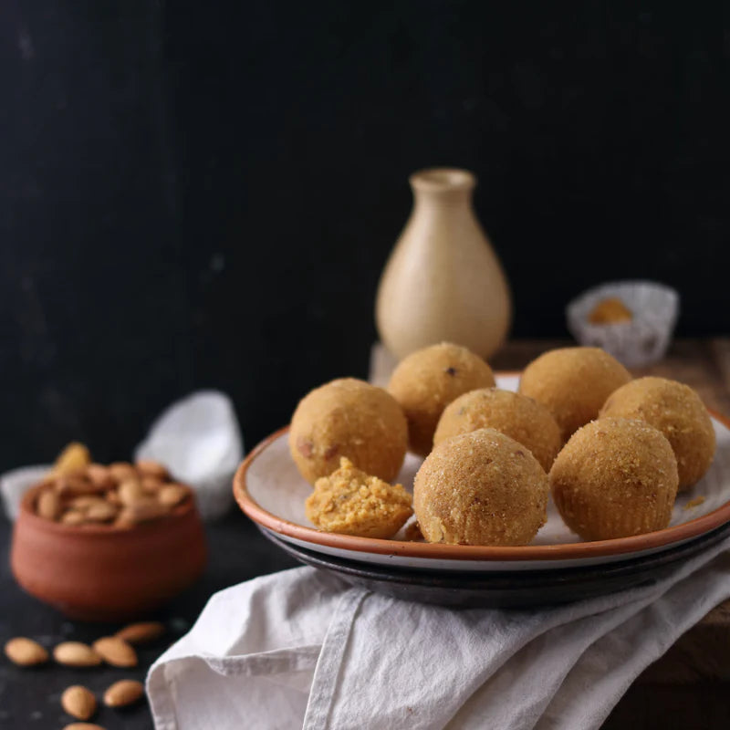 Plate of Almond House Besan Laddus placed on a white cloth with almonds in background