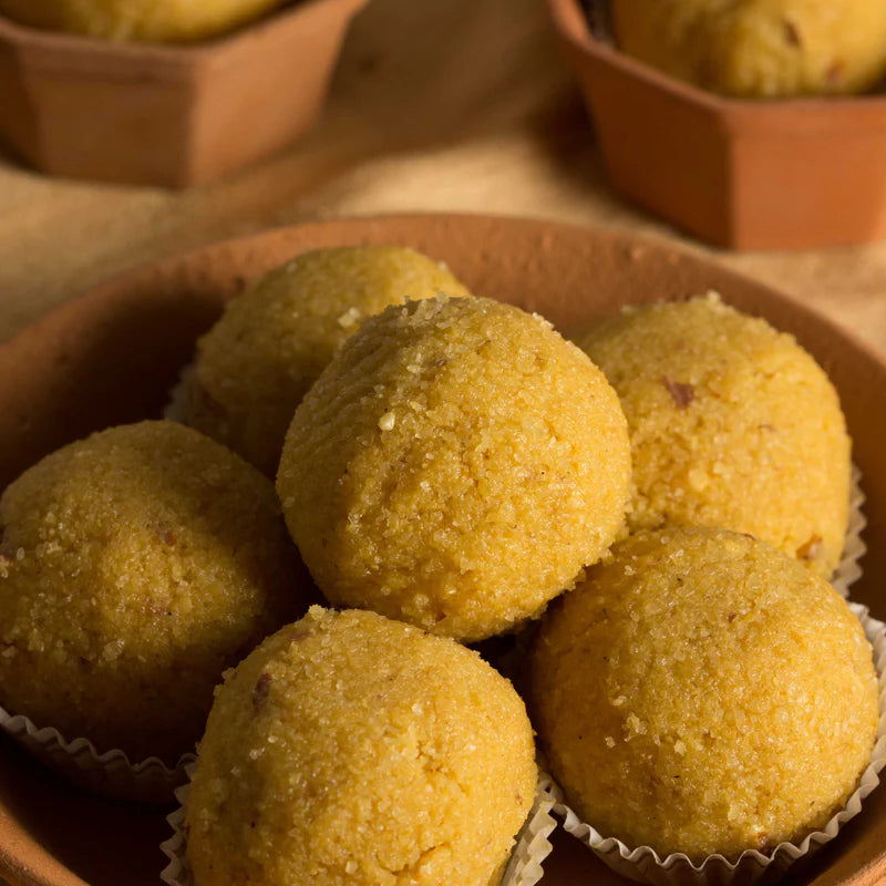 Close-up of Almond House Besan Laddu served in a traditional terracotta bowl