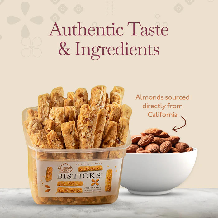 Almond House Bisticks container filled with crunchy almond cookies, placed beside a white bowl of almonds sourced from California, with text 'Authentic Taste & Ingredients'.