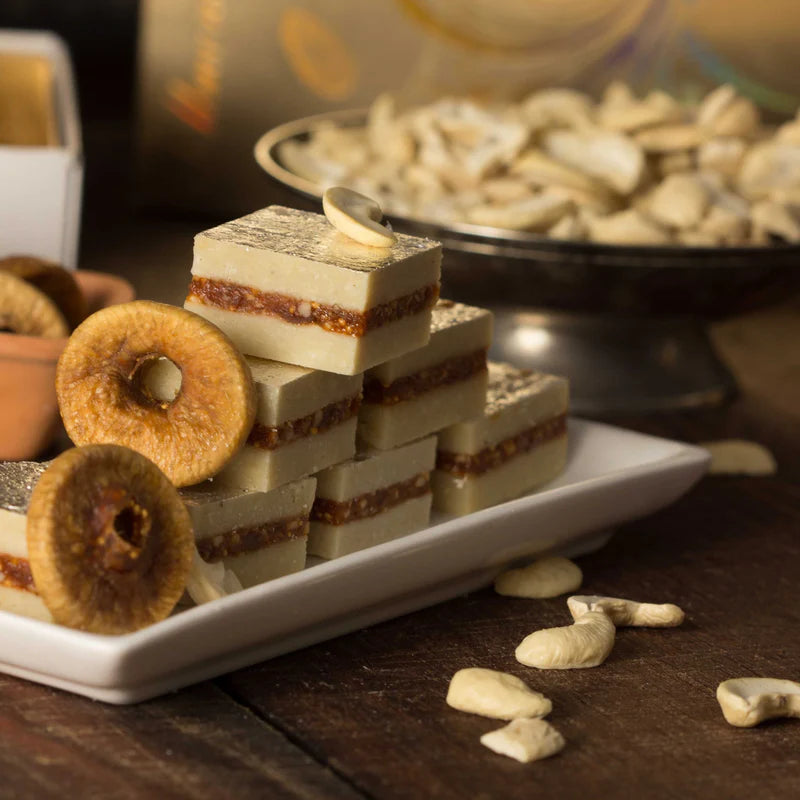 Kaju Anjeer Burfi with figs and cashew nuts displayed on a wooden table