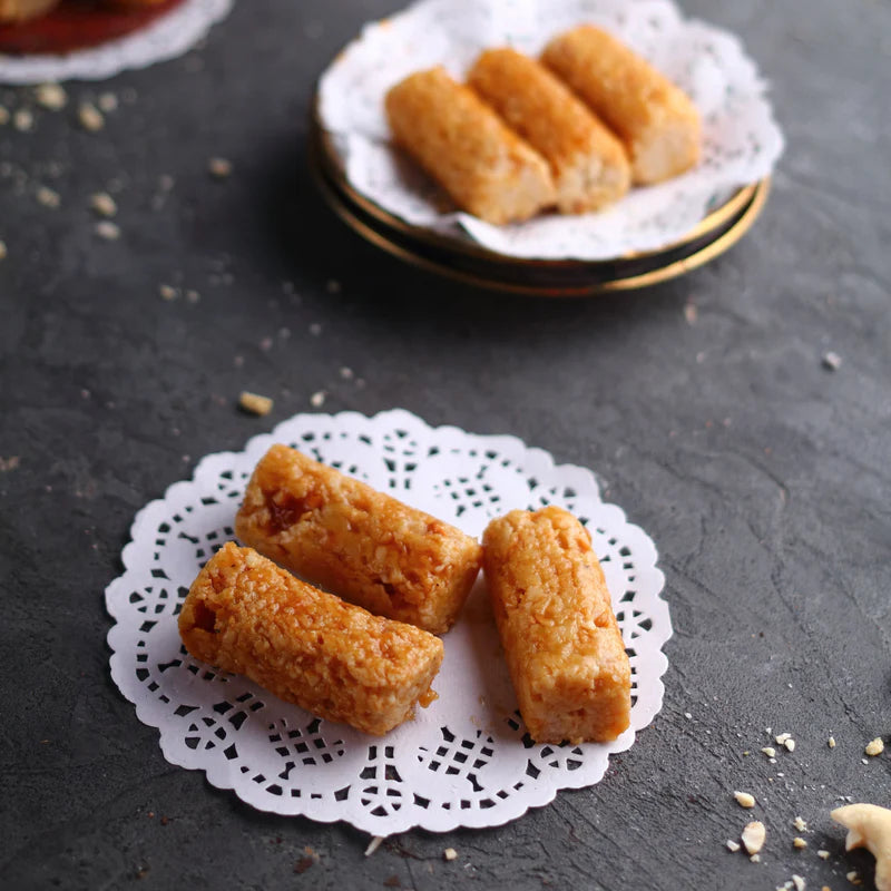 Almond House Kaju Butterscotch Roll sweet placed on decorative white doily