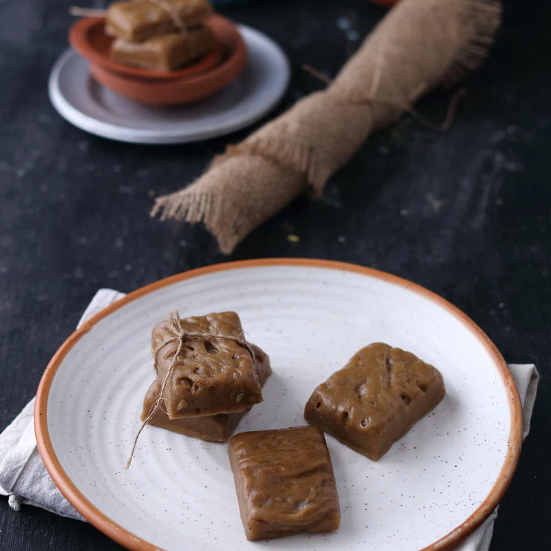 Assorted Almond House Son Patti sweets served on a ceramic plate with rustic wrapping