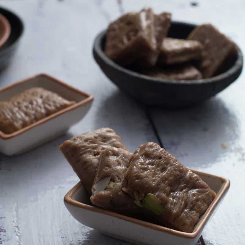 Close-up of Almond House Son Patti sweet pieces in ceramic bowls