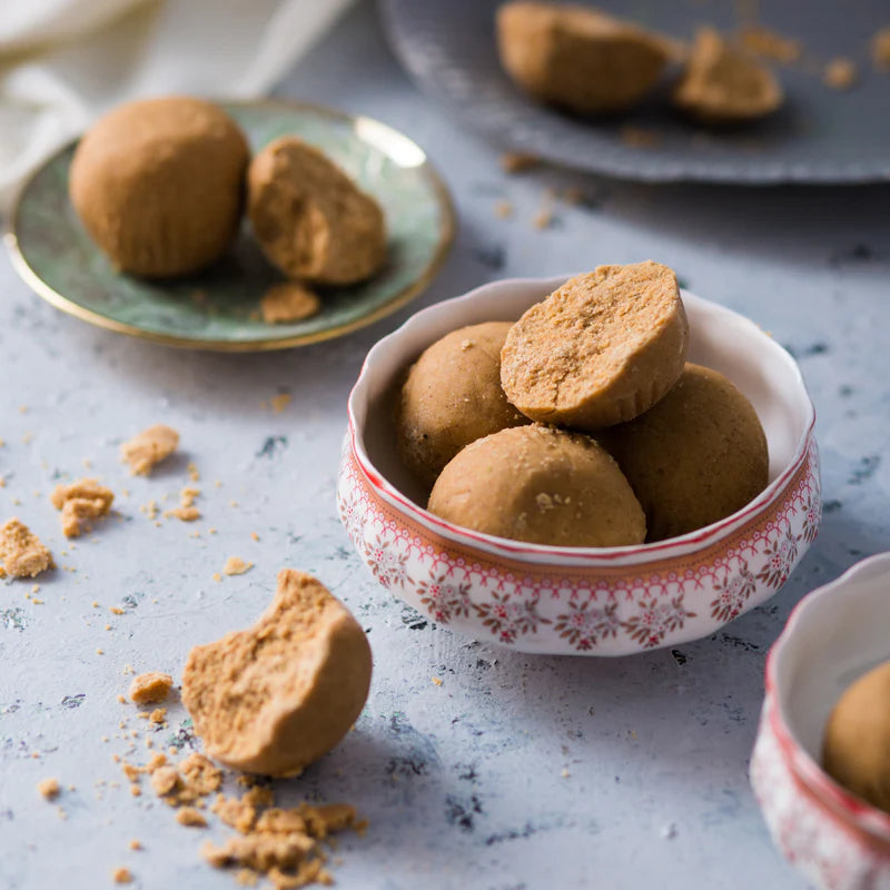 Almond House Sunni Laddu served in a decorative bowl with crumbled pieces around