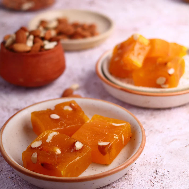 Delicious yellow-orange Bombay Halwa garnished with dry fruits, served on plates