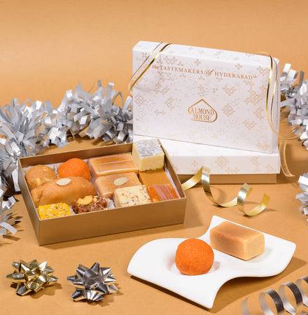 Almond House Assorted Sweets box featuring 12 varieties of traditional Indian sweets in elegant gift packaging, displayed with festive decorations.