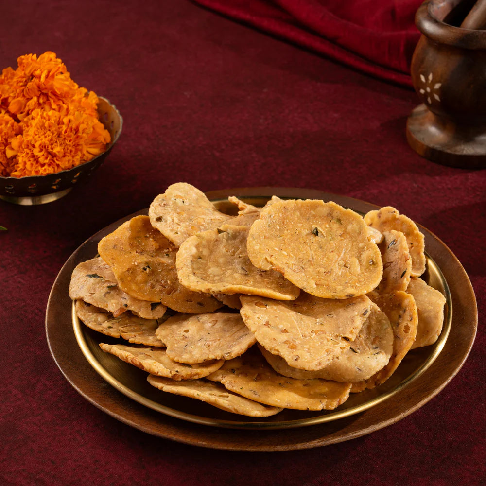 Crispy South Indian Masala Chekkalu served on a brass plate with festive decor in the background