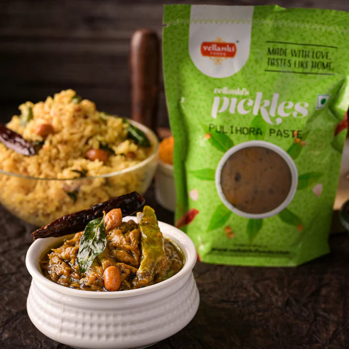 Vellanki Foods Pulihora Paste pack with a bowl of pulihora rice and tamarind spice mix in the foreground – traditional South Indian dish setup.